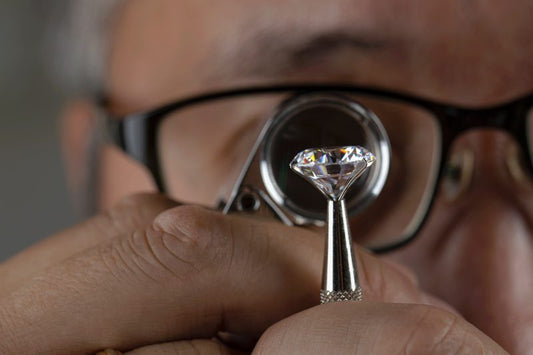 Diamond expert inspecting a loose diamond with a jeweler's loupe to evaluate clarity and quality.